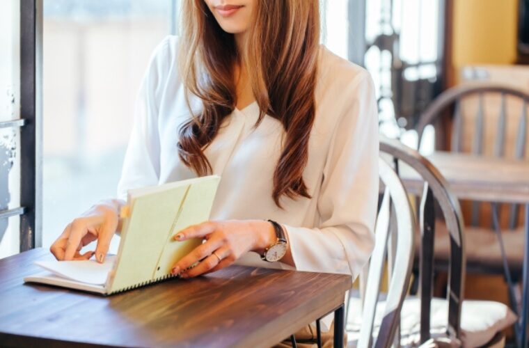 カフェで手帳を開く女性